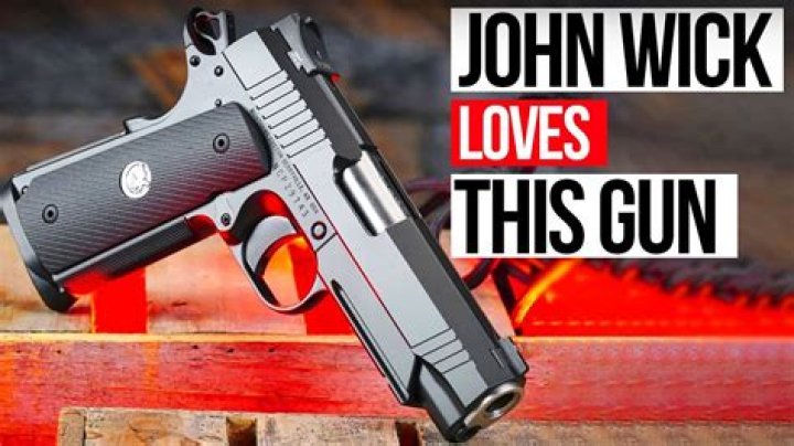 How does John Wick hold his gun?